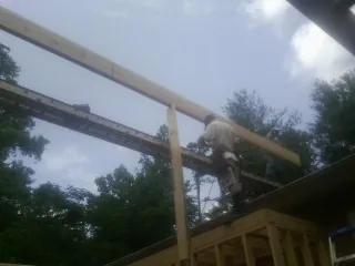Carpenter setting a ridge beam over a new addition frame — Ice Dam Removal by Roofing Brothers in Oaks