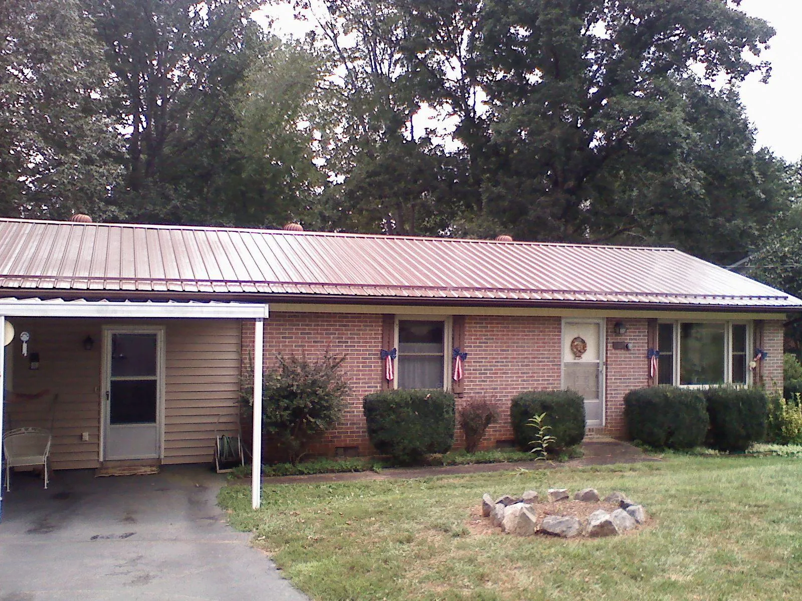 Bronze metal roof and carport on a brick ranch home — Roof Repair work by our crew in Oaks